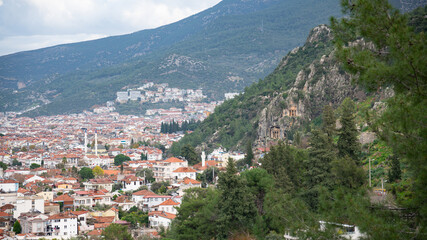 Fototapeta premium City and Ancient Rock Tombs on Forested Hillside 