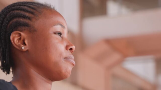 woman exhaling deeply after stair climb, side profile shows heavy breathing and sweat, postworkout recovery scene, model acting as runner catching breath, warm urban architecture in background,