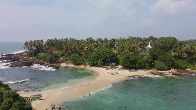 A top view of the sandy isthmus between the island and the mainland. The Blue Island, located at the southern tip of Sri Lanka, is becoming an increasingly popular tourist destination. A tropical dron
