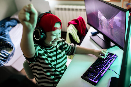Teen gamer celebrating pc victory at home
