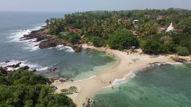 A top view of the sandy isthmus between the island and the mainland. The Blue Island, located at the southern tip of Sri Lanka, is becoming an increasingly popular tourist destination. A tropical dron