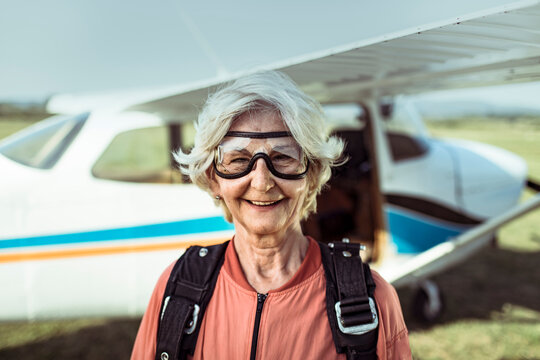 Smiling senior woman skydiver at rural airfield