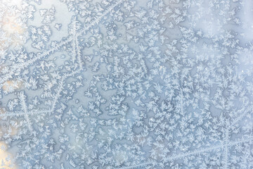 Fototapeta premium A background of frost patterns and frost crystals on a window. Frosted windowpane.