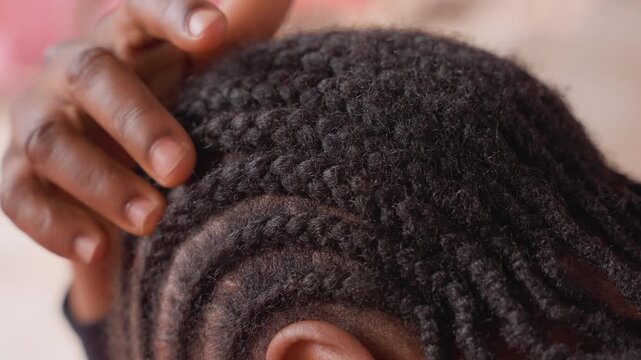 closeup black girl touching cornrows grooming ritual, gentle fingers adjusting braids and patterned rows, focus on textured scalp and protective style, intimate athome haircare moment for beauty