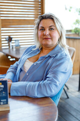 A portrait of a beautiful, overweight woman in a cafe. The psychology of happiness and confidence.