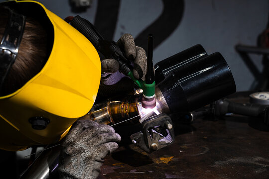 Precision TIG welding on custom exhaust pipe using argon by welder