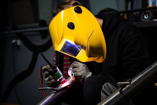 Precise TIG welding of car exhaust pipe using argon by professional welder