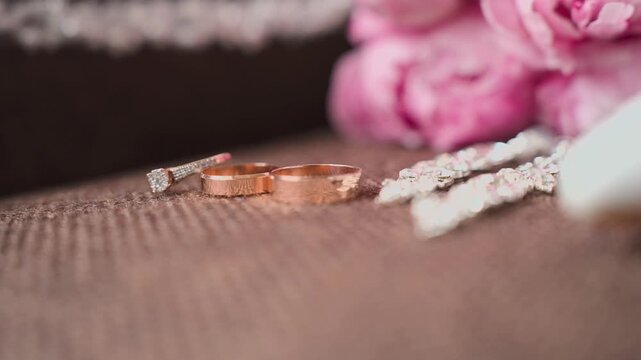 Wedding gold rings captured from an unusual angle, slow motion. Contemporary style