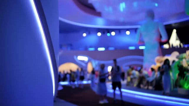 People exploring futuristic technology exhibition with vibrant blue neon lights