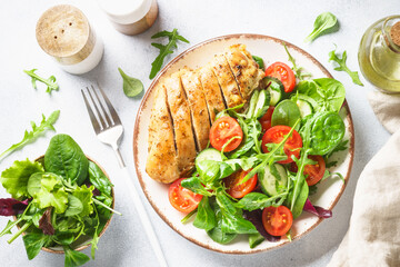 Green salad with chicken fillet on white.