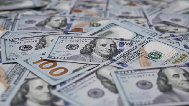 US hundred-dollar banknotes laid out on a surface. Money, finance, savings, investment and business concept.
