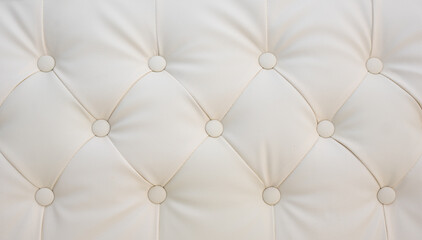 Cream colored tufted leather upholstery with elegant buttons, luxurious interior design and high-end furniture