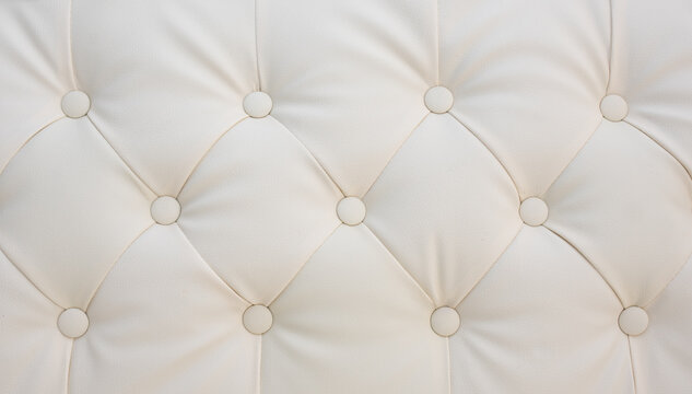 Cream colored tufted leather upholstery with elegant buttons, luxurious interior design and high-end furniture