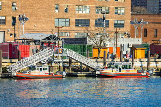 New-York, USA - 15.01.2026: FDNY fireboats docked along the waterfront near industrial buildings and apartment towers in New York City