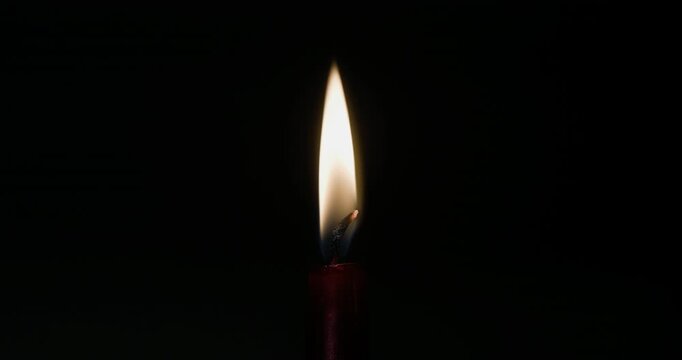 Candle flame flickering slowly in the dark. High-quality loop video with isolated light source. Perfect for overlays, romantic or spiritual scenes, or emotional visual effects.