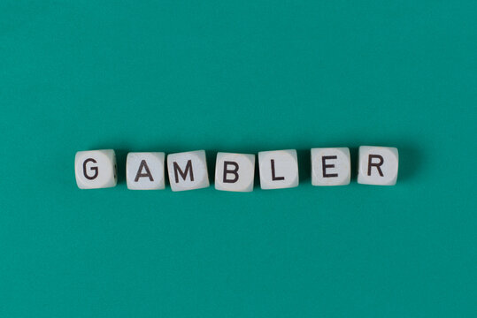 Siete dados que forman la palabra "gambler", sobre fondo verde