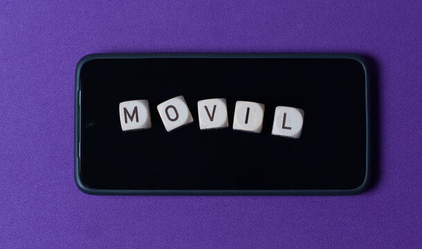 Cinco dados que forman la palabra "movil" encima de un m&oacute;vil, sobre fondo morado