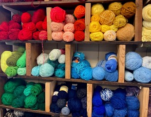 colorful yarn organized on wooden shelves
