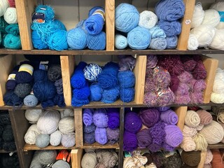 colorful yarn organized on wooden shelves