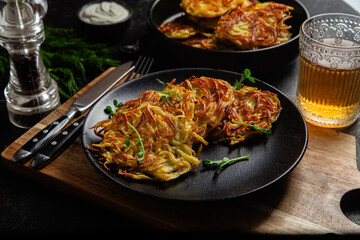 Golden Potato Pancakes with Sour Cream and Fresh Dill on a Dark Table
