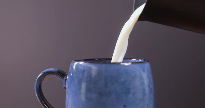 Steam rising from a hot drink in a cup against a dark background
