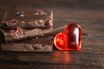 Delicious, dark chocolate with a red heart on a dark background for Valentine's Day
