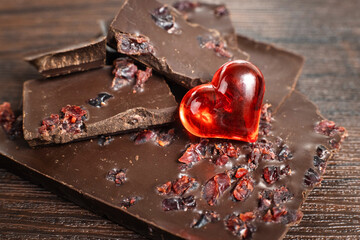 Delicious, dark chocolate with a red heart on a dark background for Valentine's Day