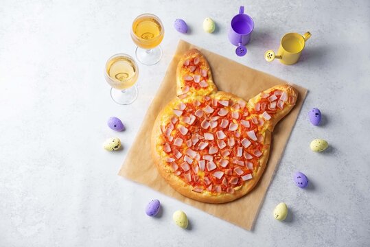 Tomato and ham pizza in the form of rabbit on a white background for Easter holidays