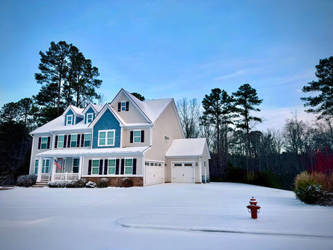 A beautiful coloniasl style family home in the snow at dawn