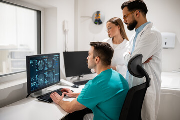 Medical team analyzing mri scan results on computer