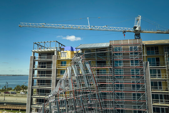 Aerial view of ruined by hurricane Ian construction scaffolding on high apartment building site in Port Charlotte, USA