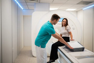 Radiologist assisting woman preparing for mri scan