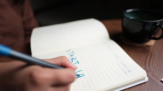 freelancer start-up, New business venture bold text on blank ruled page diary on wooden desk, start-up business concept stock video in 4k pro res