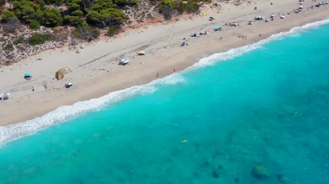 Nudist people beach in Greece. Naked man an woman naturist at beautiful ocean aerial drone shot