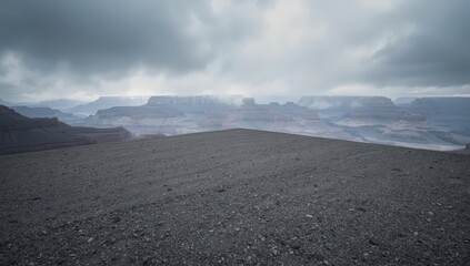 Square of gravel and dirt near the Grand Canyon with mountains on a cloudy day