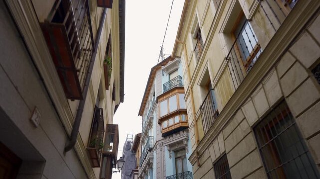 Beautiful facades with balconies and windows in the narrow streets of the city of Toledo, Spain.