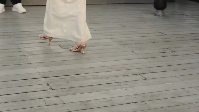 bride walking caucasian woman in flowing gown and strappy heels across wooden deck, elegant stride and fabric