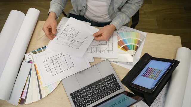 Designer studying blueprints and color samples
