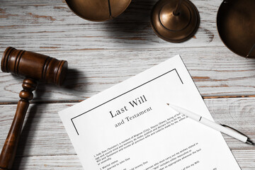 Last Will and Testament, gavel, pen and scales on wooden table, flat lay