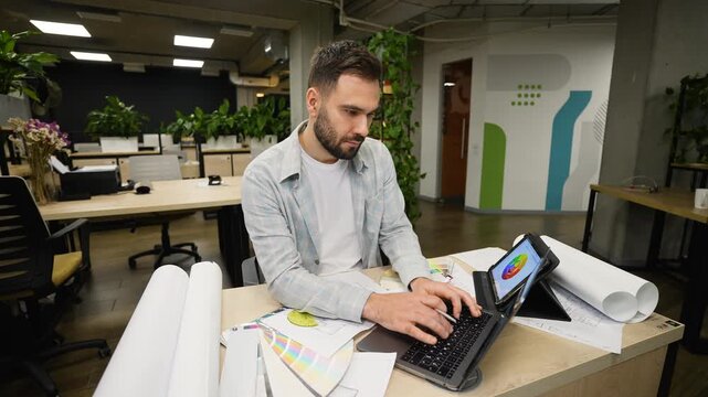 Focused male architect drawing a blueprint project in a modern office
