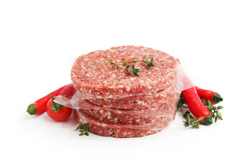Naklejka premium Uncooked meat patties with thyme, chili peppers and tomato isolated on white