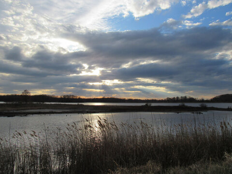 Serenity speaks, as the sun begins to set, and heavenly rays of sunlight beam down through the clouds. Wetland scenery, Bombay Hook National Wildlife Refuge, Kent County, Delaware.