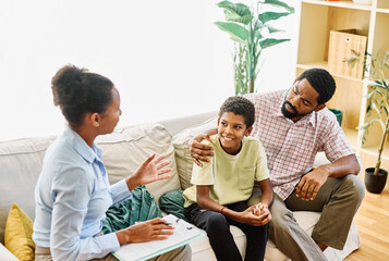 Fatherwith his teenage son boy at meeting with social worker, psychologist discussing mental health...