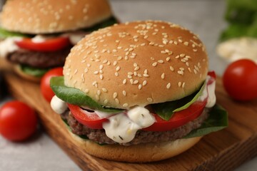 Delicious burgers with meat patties on grey table, closeup
