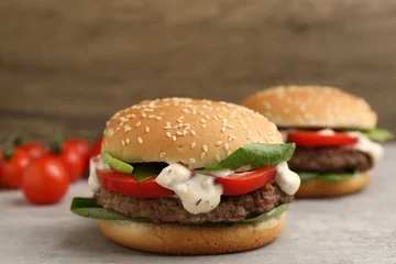 Fotobehang Eten Delicious burgers with meat patties on grey table, closeup  © New Africa