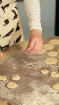 Close-up of hands arranging rolled dumpling dough circles
