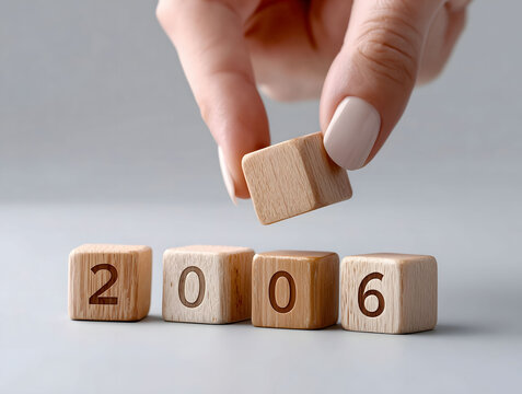 A closeup of four wooden cubes standing in a row The first cube has the number two written on it the second cube has the number zero written on it the third cube has t
