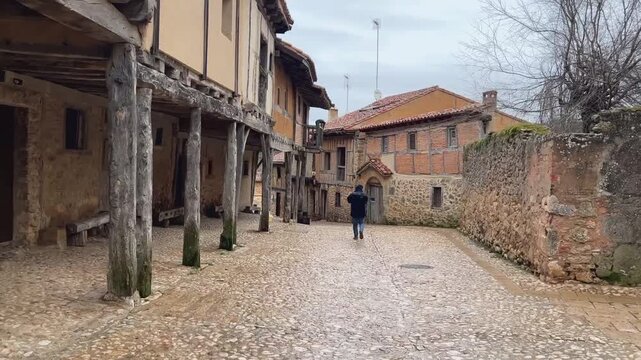 Hombre caminando por una calle medieval en Calata&ntilde;azor