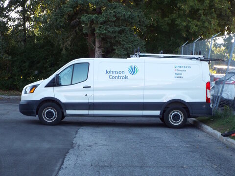 Ottawa, ON, Canada-July 11,2025: The side profile of a white "Johnson Controls" service van parked outdoors,Lola St.
