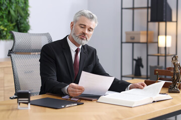Notary in suit doing paperwork at table in office